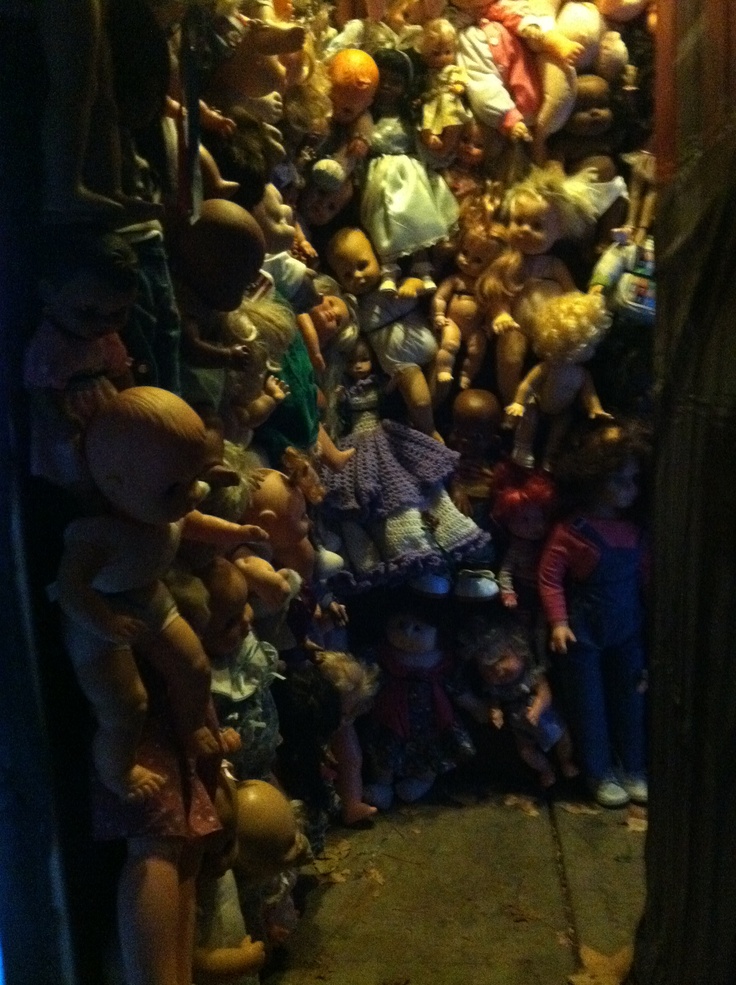 a large amount of dolls are stacked on the wall