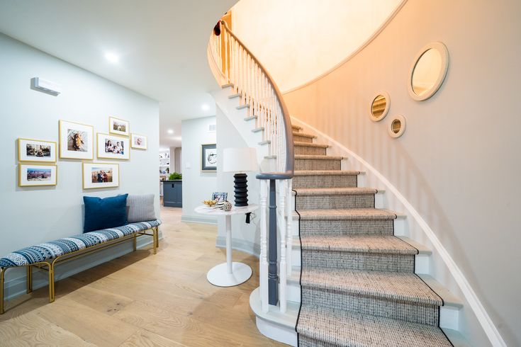 there is a staircase in the living room with pictures on the wall and carpeted floor