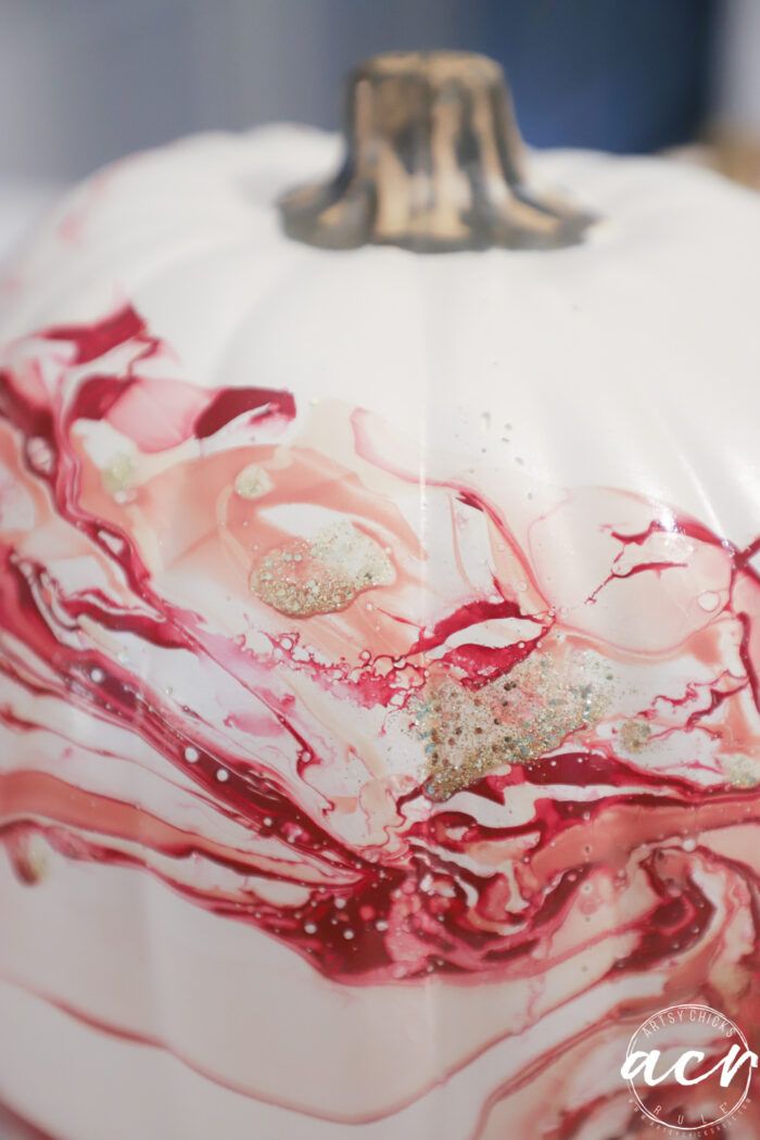 a white and red painted pumpkin sitting on top of a table