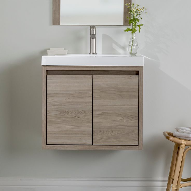 a bathroom vanity with a mirror above it and a wooden stool in front of it