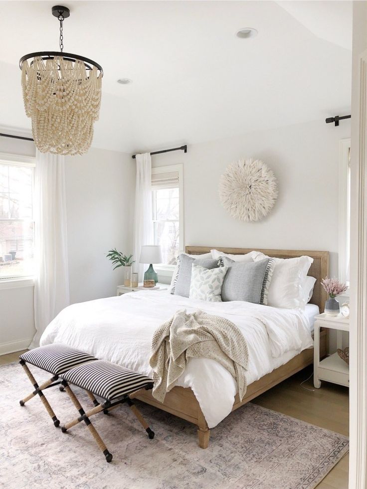 a bedroom with a large bed and chandelier hanging from it's ceiling