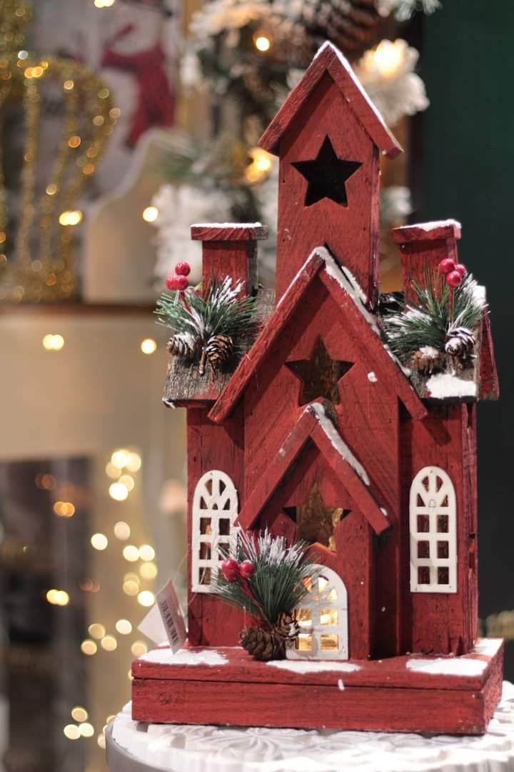 a red wooden house with christmas decorations on top