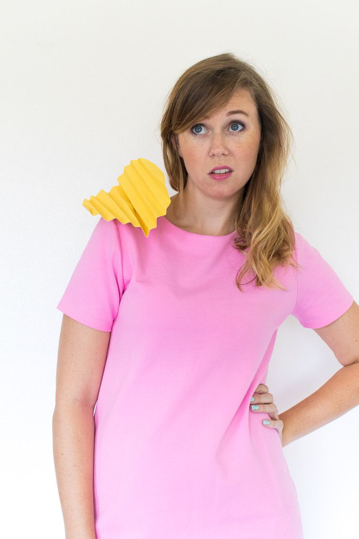 a woman wearing a pink shirt and holding a yellow piece of paper