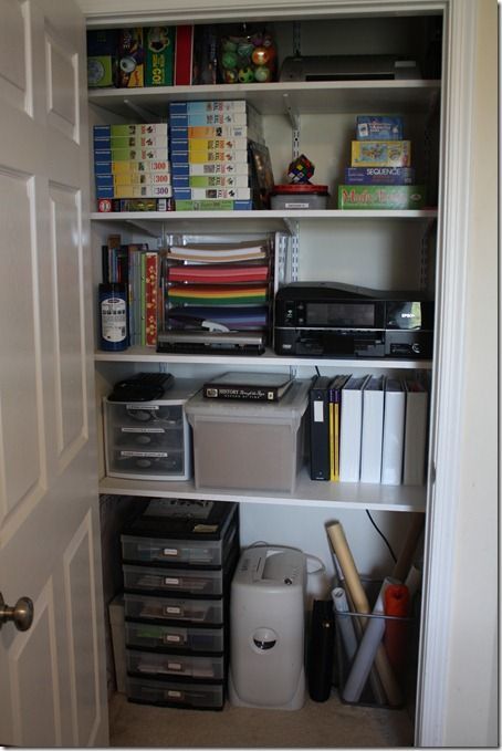 an open closet with various items on shelves and bins in front of the door