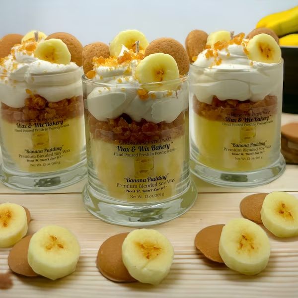 three desserts with banana slices and whipped cream on top are arranged in individual glass containers