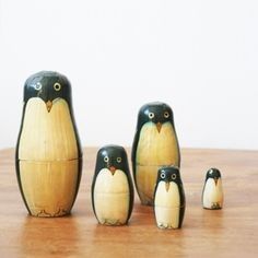 a group of small wooden penguins sitting on top of a wooden table next to each other