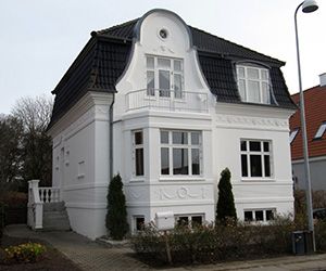 a large white house sitting on the side of a road