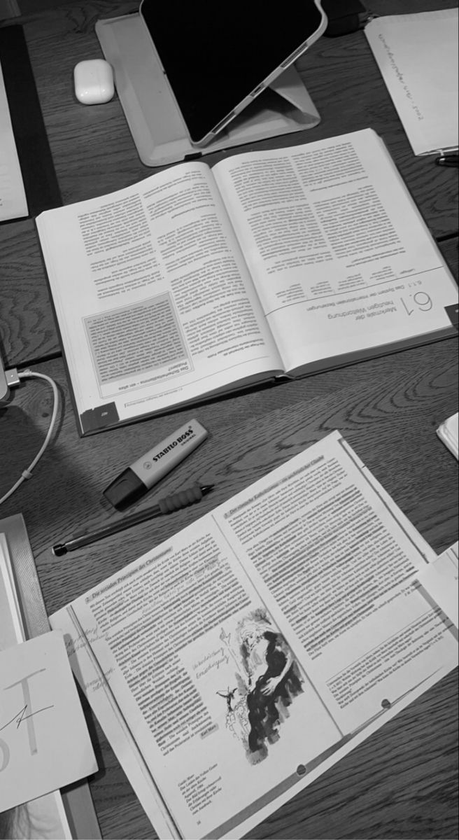 an open book sitting on top of a wooden table next to a computer mouse and keyboard