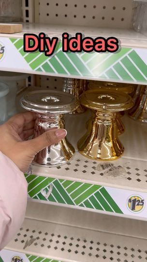 a hand is pointing at the bottom of a shelf in a store with decorative items on it