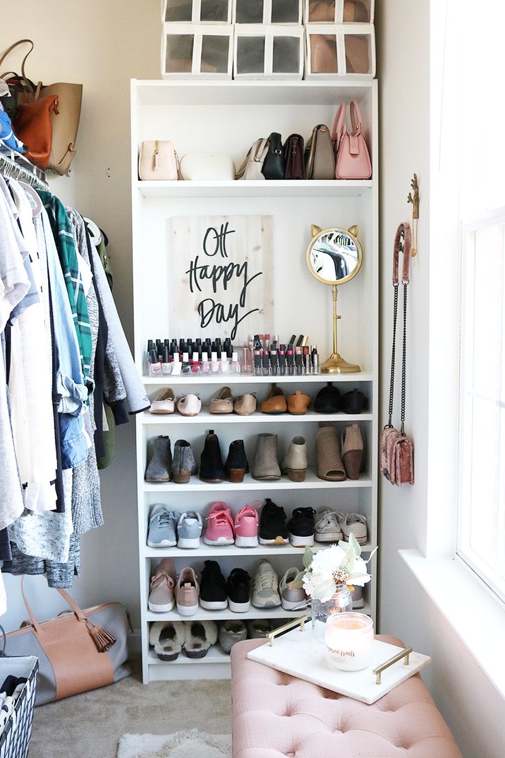 an organized closet with shoes and handbags on shelves next to a pink bench in front of a window