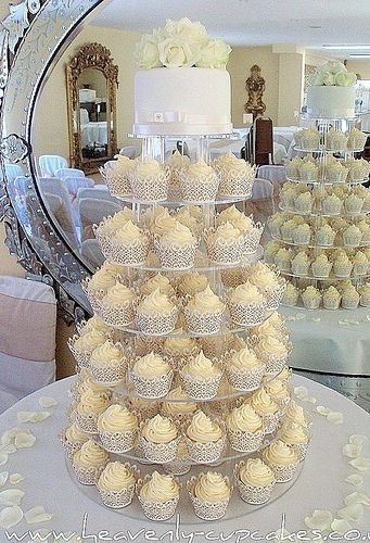 a wedding cake with cupcakes stacked on it