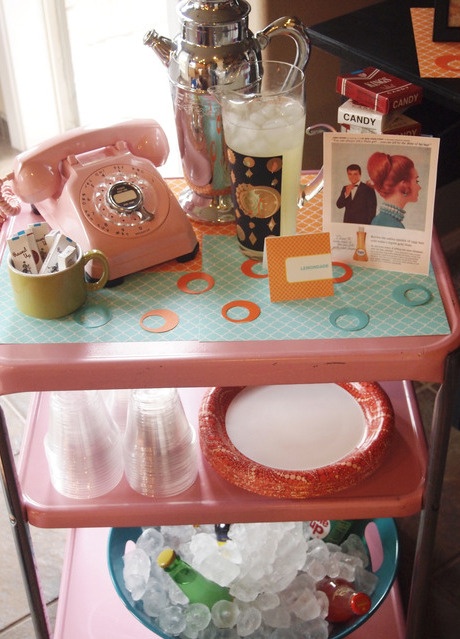 a pink telephone sitting on top of a table next to plates and cups with drinks