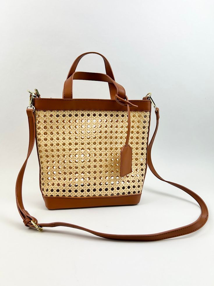 Stylish and perfect for the season, this woven rattan bag is the cutest accessory for all your summer outings! Product Details Material: Vegan Leather & Rattan Size: 10"L x11"W 5" Handle Drop Comes with side hooks to attach a longer shoulder strap One crossbody strap included Handwoven Leather Bucket Bag For Vacation, Brown Rattan Tote Straw Bag, Summer Light Brown Straw Bag With Braided Handles, Brown Jute Shoulder Bag For Spring, Rattan Straw Bag With Open Weave For Everyday Use, Spring Top Handle Woven Leather Straw Bag, Light Brown Bucket Straw Bag For Summer, Open Weave Straw Bag For Everyday Use, Summer Light Brown Bucket Bag With Braided Handles