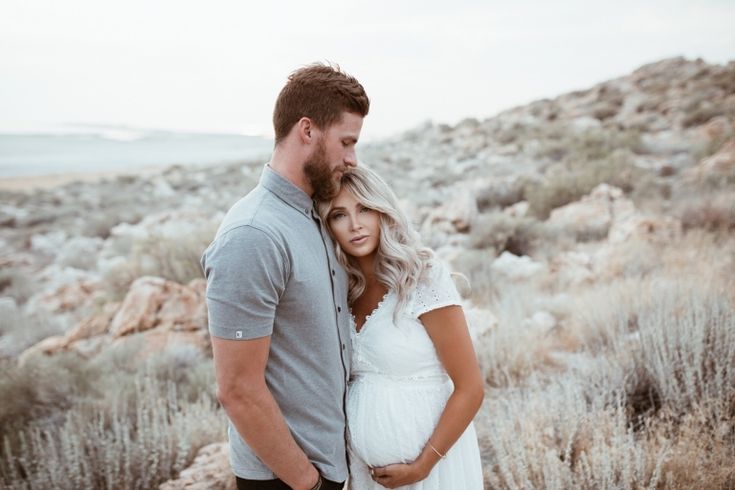 a man and woman standing next to each other in the desert