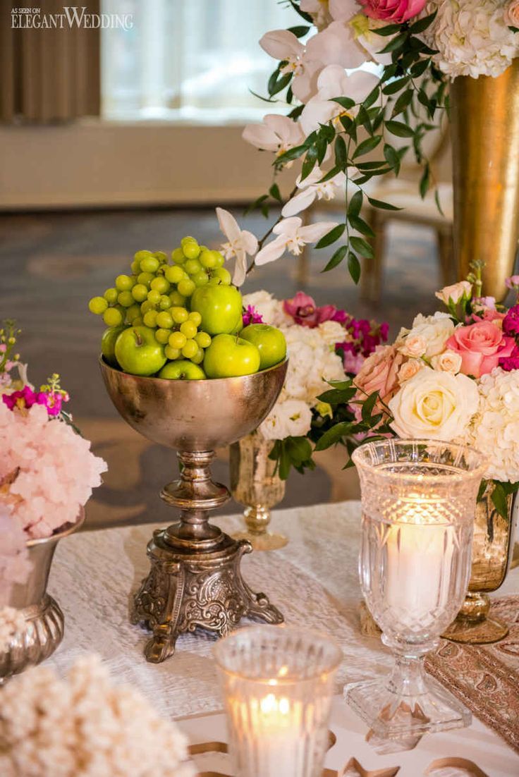 a table topped with lots of flowers and fruit