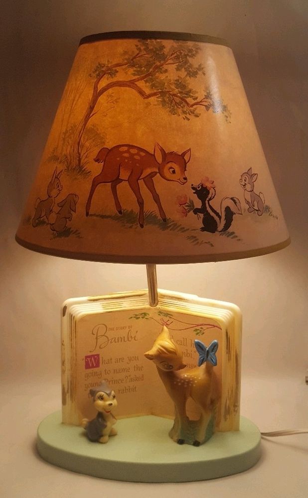 a lamp that is on top of a table with a deer and mouse figurine underneath it