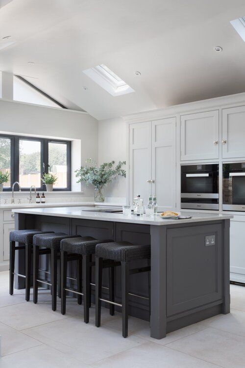 a kitchen with an island and four stools in front of the counter top area