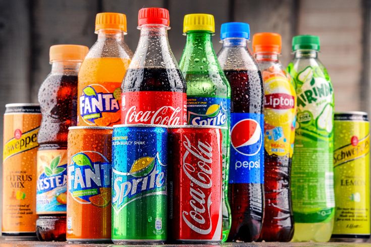 many different types of sodas lined up on a table