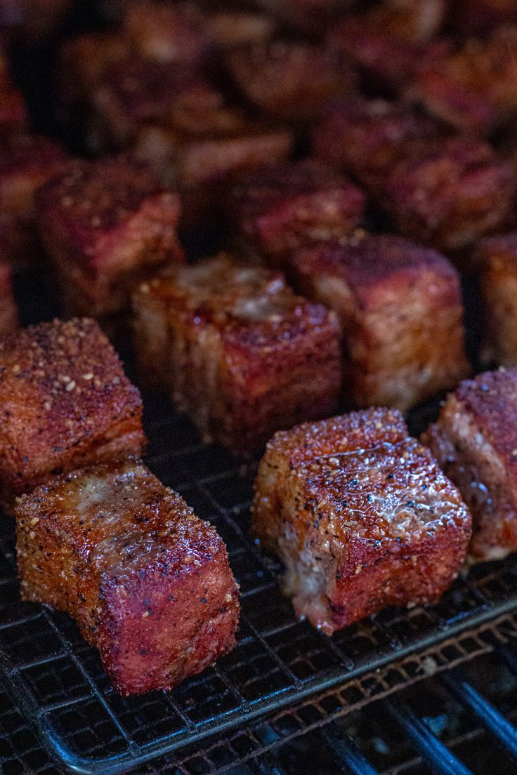 several pieces of meat cooking on a grill