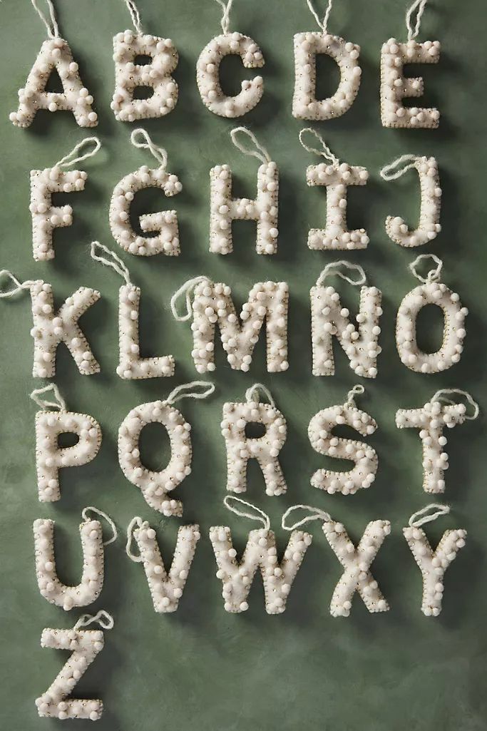 the letters and numbers are made out of plastic beads on a chalkboard background with string