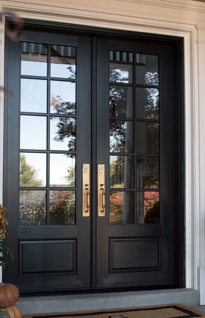 the front door is black and has two glass panels on it, along with a welcome mat