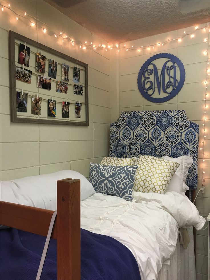 a bedroom with string lights and pictures on the wall above the headboard is decorated with blue and white bedding