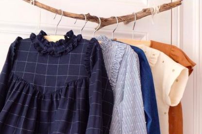 clothes hanging on a clothes line in front of a white door with wooden hangers