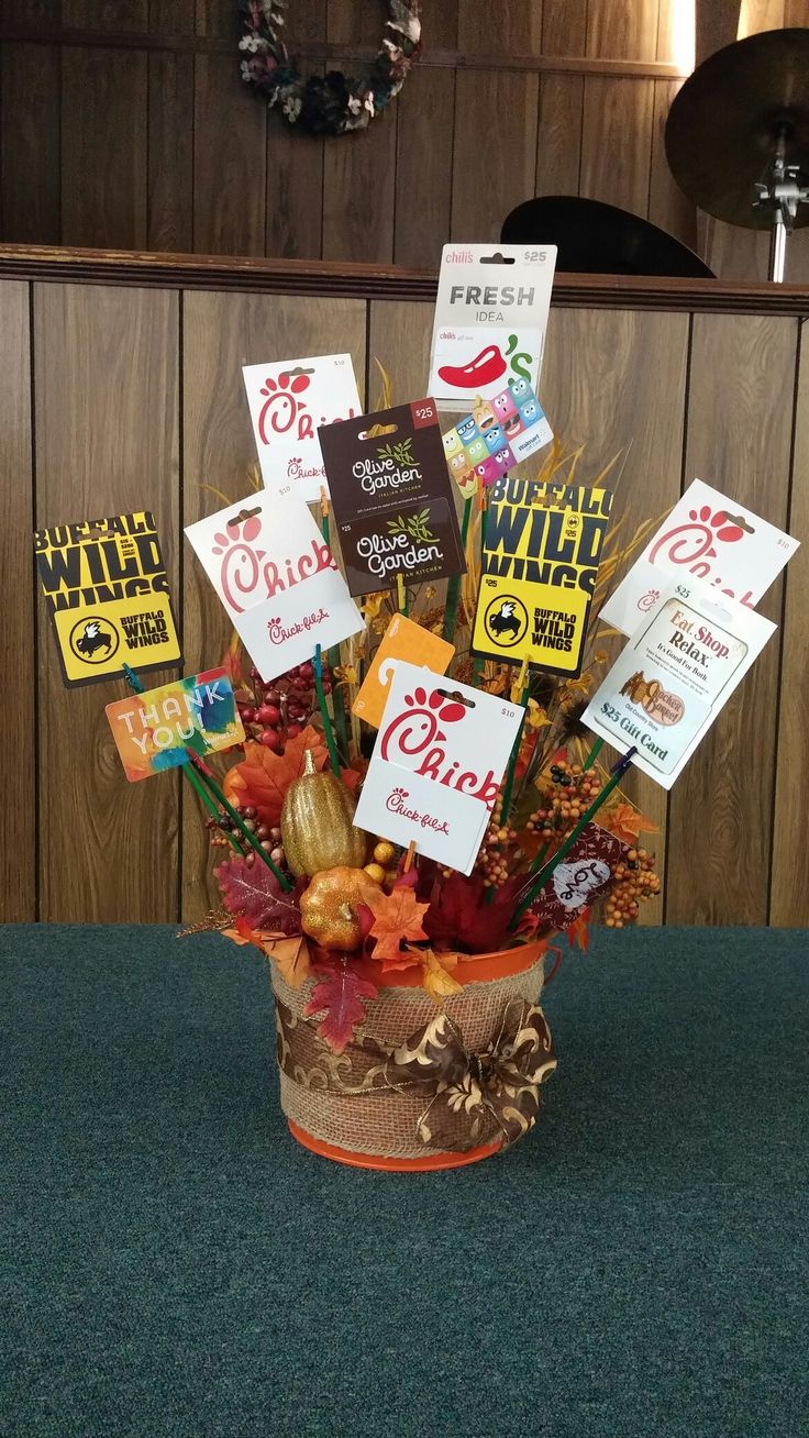 a basket filled with lots of candy and cards on top of a table next to a wooden wall