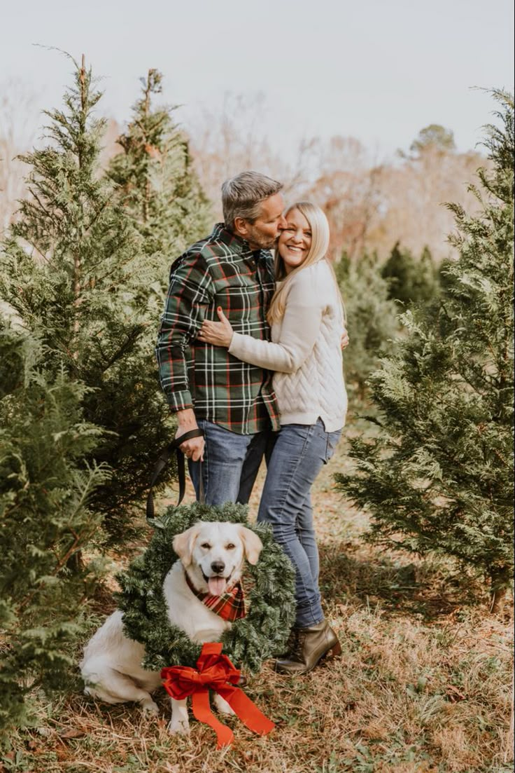 a man and woman standing next to a dog