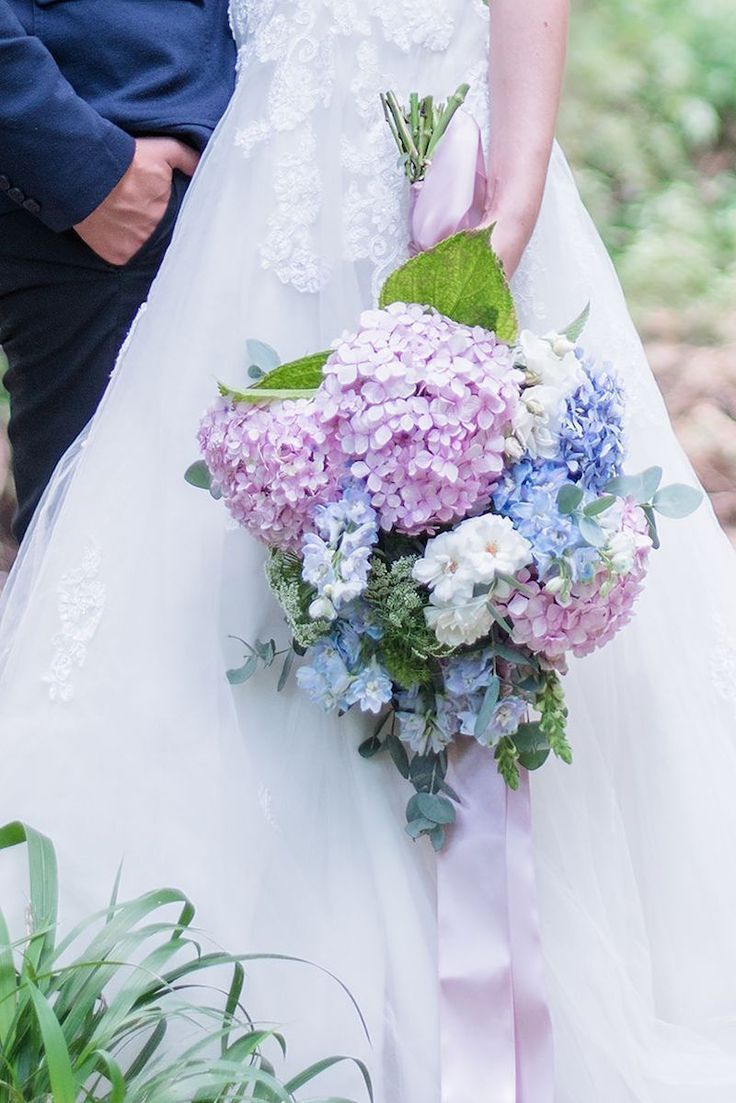 the bride and groom are holding their wedding bouquet