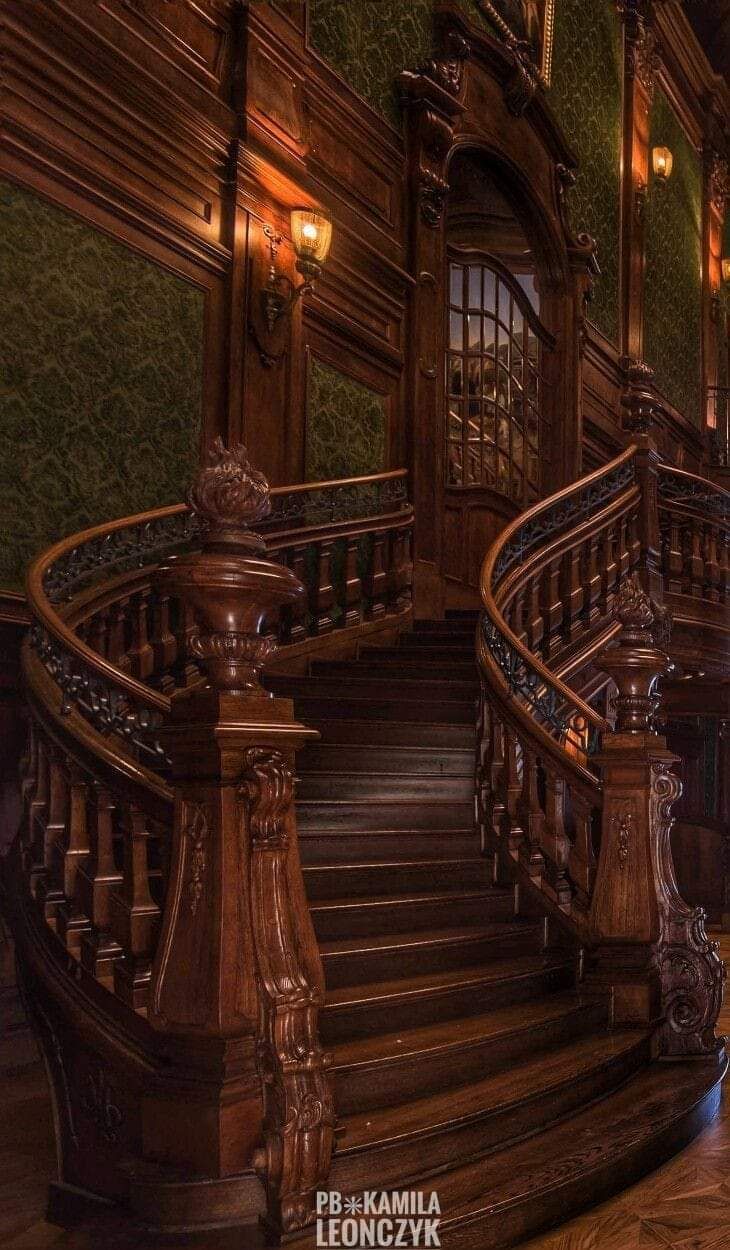 an ornate wooden staircase leading up to the second floor