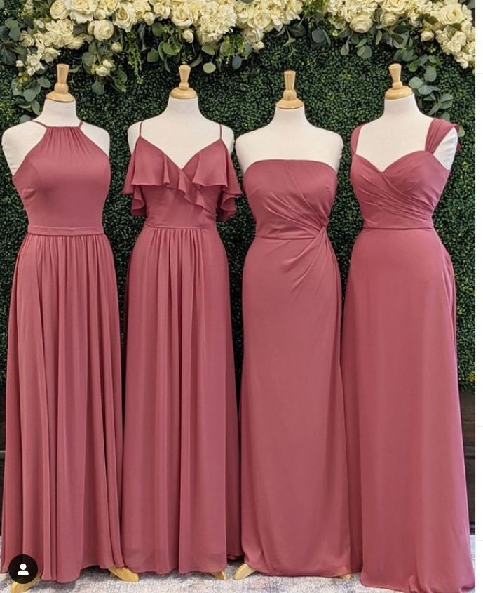 three bridesmaid dresses on mannequins in front of a floral wall