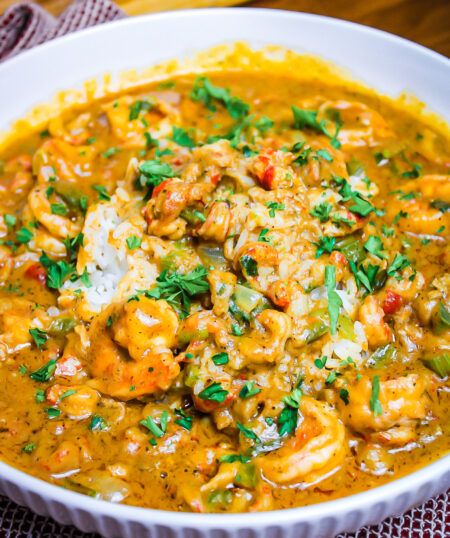 a white bowl filled with shrimp and tortilla soup on top of a table