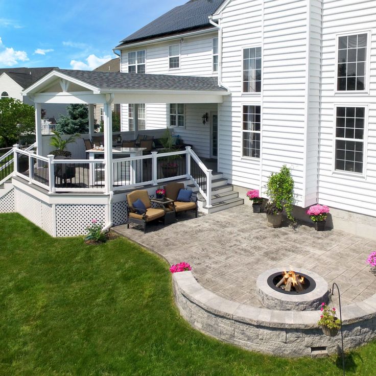 a large white house with a fire pit in the middle of it's yard