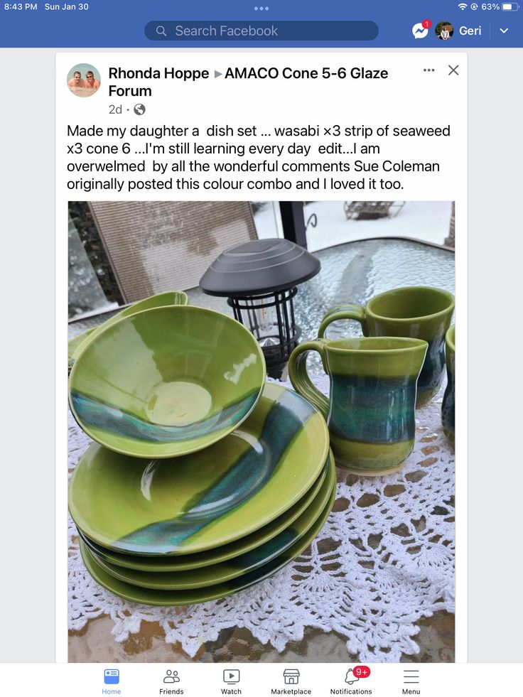 a table topped with lots of green plates and cups on top of a doily