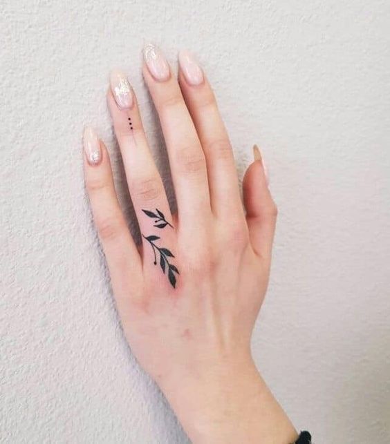 a woman's hand with a small tattoo on it