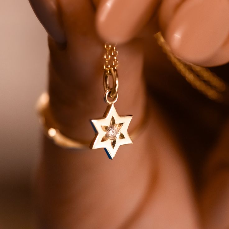 "Magen David pendant necklace with diamond, crafted in 14k gold, A Star of David necklace, a symbol of Jewish faith and heritage, a beautiful piece of Israeli Jewelry. This meaningful Magen David pendant necklace represents the enduring strength and spirit of the Jewish people. The 'Magen David' is an iconic symbol of Judaism, signifying its significance and unity. The blue sapphire signifies Israel's connection, and the gold and diamonds represent the beauty and strength of faith. This necklace Elegant Star Of David Birthstone Jewelry, Luxury Star Charm Jewelry For Anniversary, Star Shaped Diamond Necklace For Anniversary, 14k Gold Star Of David Jewelry For Anniversary, Fine Jewelry Star Of David Necklace For Formal Occasions, 14k Gold Star Of David Necklace For Anniversary, Luxury Anniversary Jewelry With Star Charm, Dainty Star Of David Jewelry For Anniversary, Anniversary Star Shaped Diamond Necklace