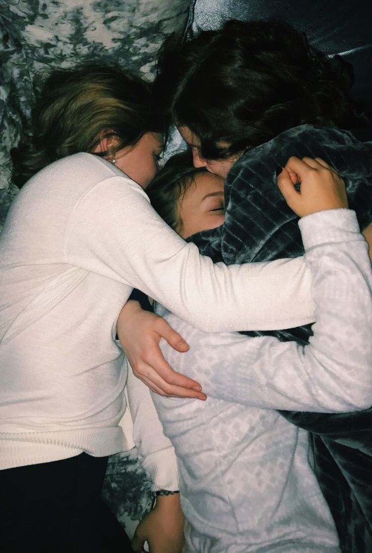 two women hugging each other while laying in bed