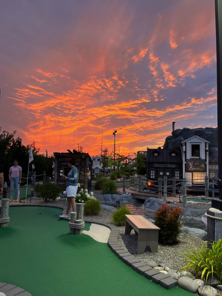 people are playing miniature golf at sunset