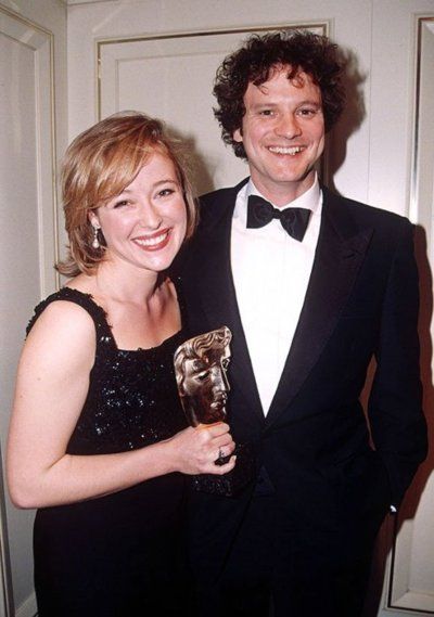 a man in a tuxedo standing next to a woman holding an award