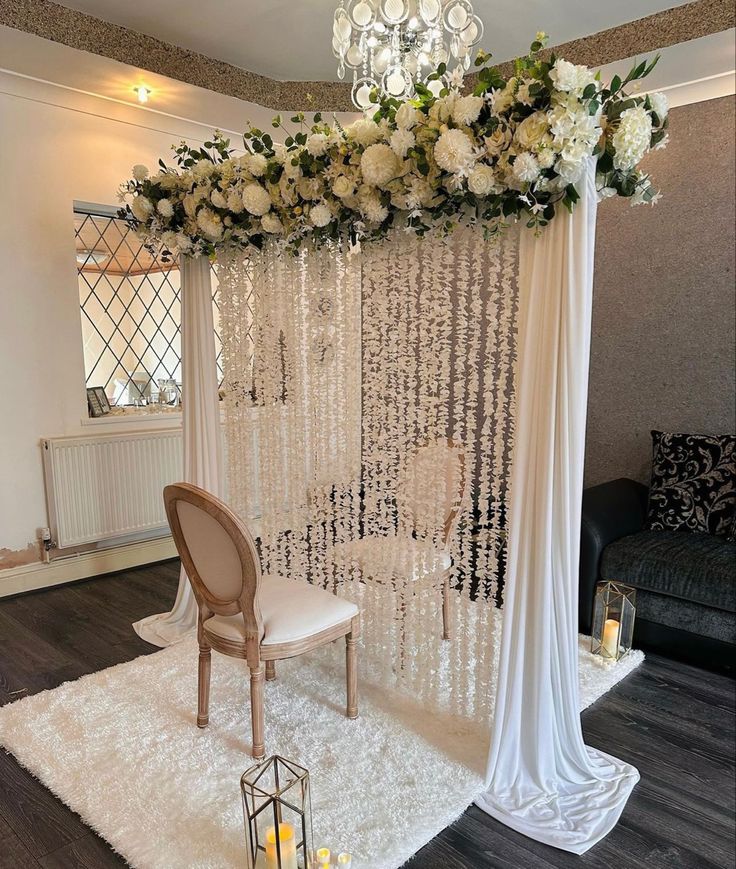 a white wedding ceremony setup with flowers and chandelier