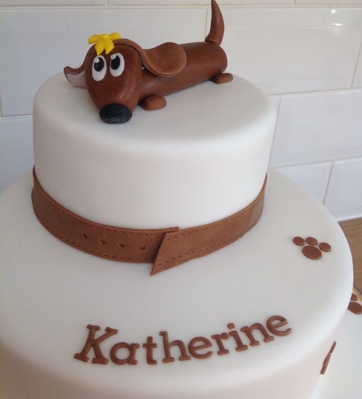 there is a cake with a dog on it that says kartheine and has brown trim around the edges