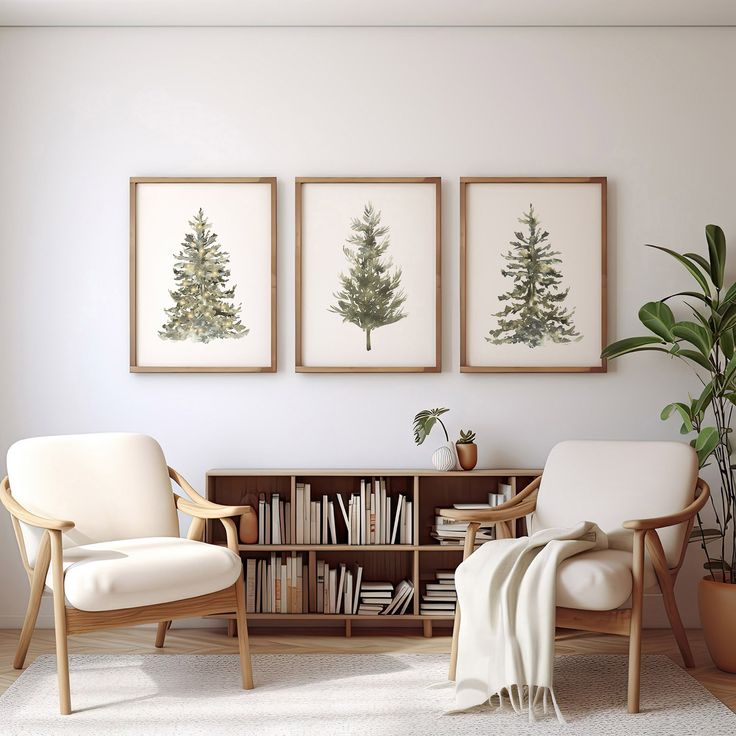 two chairs and a book shelf in a room with three framed trees on the wall