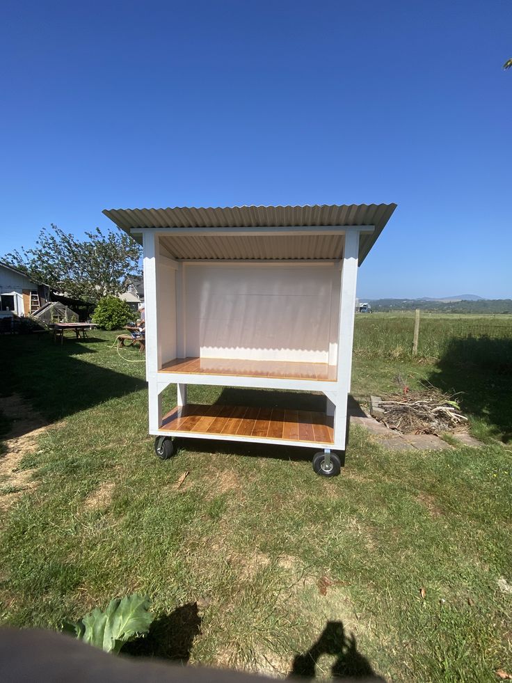 a small white cart sitting on top of a lush green field