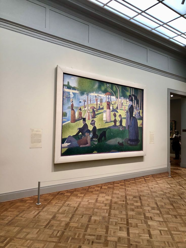 a large painting hanging on the side of a wall next to a wooden floor in an art gallery