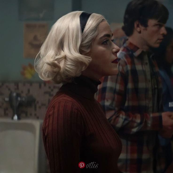 a woman with blonde hair standing next to a man in a bathroom