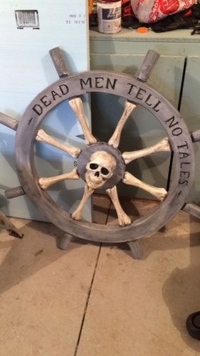 a wooden steering wheel with a skull on the spokes and words that read dead men tell no tales