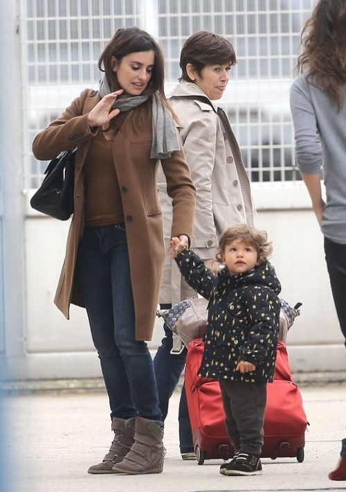 a woman and child are walking with luggage