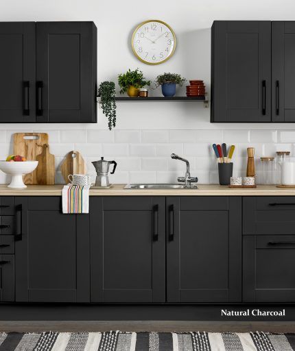 a kitchen with black cabinets and a clock on the wall