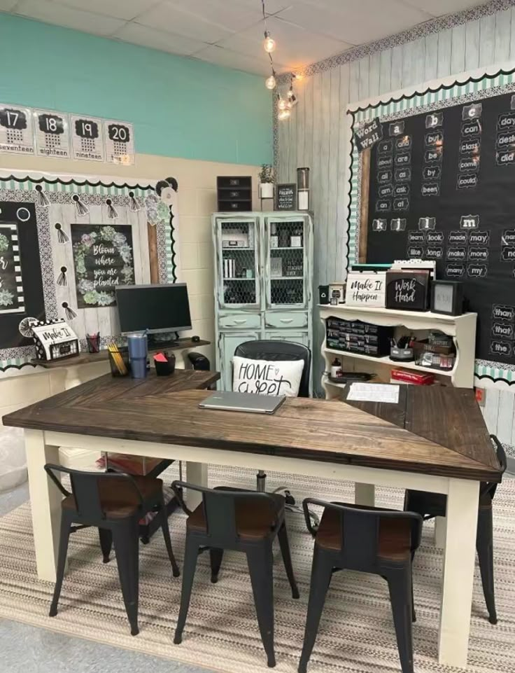 a table with some chairs around it and chalkboard on the wall in the background